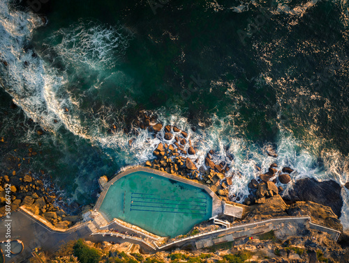 Aerial drone view of Bronte Ocean Pool in Sydney during sunrise in soft early morning light, New South Wales Australia