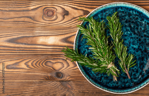Fresh rosemary on brown texture background. Fresh spice herbs. Seasoning for meat and fish. Recipe.Organic bouquet of fresh rosemary on the table.Place for text. Copy space