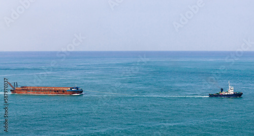 Tugboat tows a cargo barge on Japan Sea