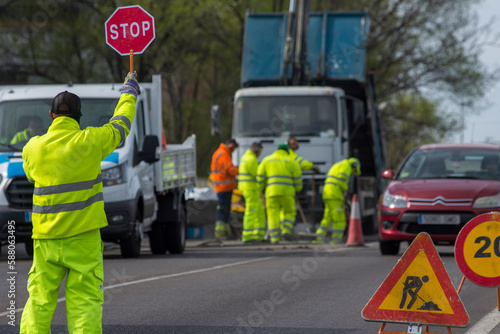 A group of construction workers are working on a road.