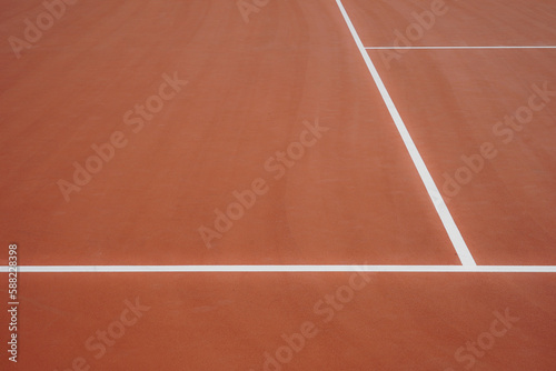 Terrain de tennis en terre battue avec les lignes extérieures blanches