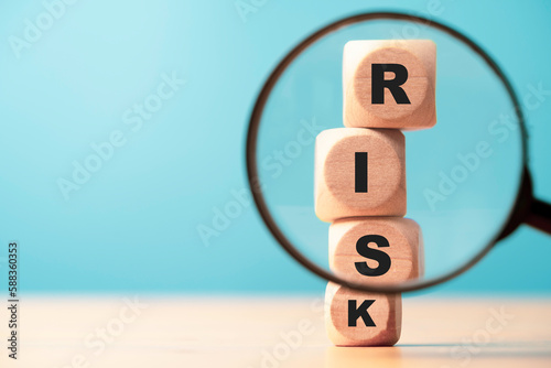 Risk wording print screen on wooden block cube and focus on magnifier glass for financial banking risk analysis and management ,Risk and return concept.