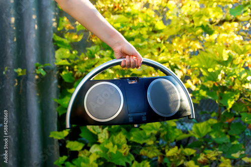 Boombox. Defocus hand holding retro music recorder on nature. Retro outdated portable stereo boombox radio receiver with cassette recorder. Vintage old style. Out of focus