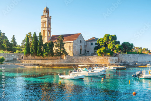 Turquoise water of Adriatic sea bay on Hvar island with franciscian monastery and boats in Dalmatia region, Croatia