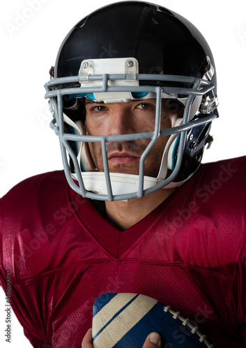 Portrait of American football player wearing helmet while standing with ball