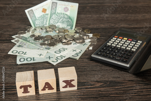 banknoty i bilon na stole obok kalkulator. Kostki z napisem TAX
