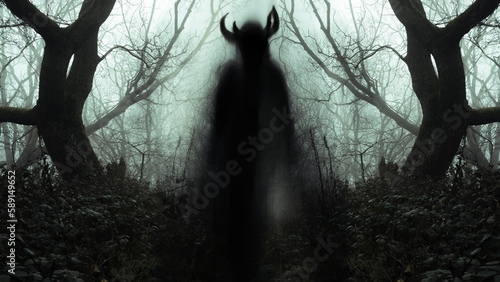 A blurred ghostly figure appearing on a path, like a pagan spirit, in a spooky forest with trees silhouetted on a moody foggy winters day.