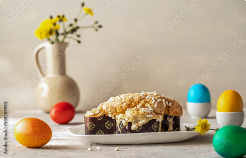 Italian Easter cake Colomba on plate with easter decoration of coloured eggs and wild flowers in vase