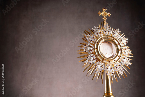 Catholic religion concept. Easter.The monstrance and golden chalice on gray background. 