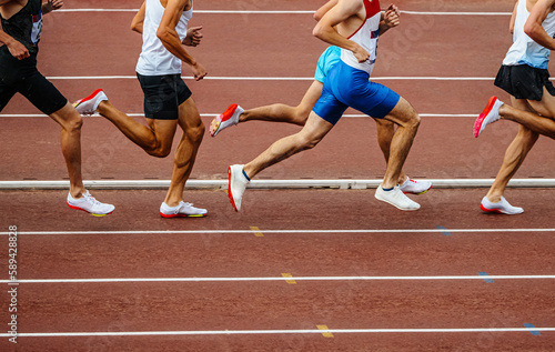group male runners running middle distance race side view, summer athletics championships at stadium, legs men jogger