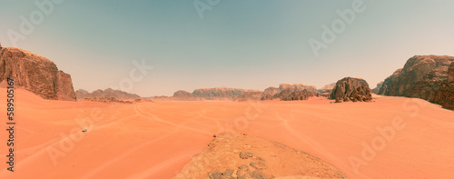 Impresionante paisaje del desierto de Wadi Rum, en Jordania, con altas montañas rocosas y caminos desérticos que guían a los turistas.