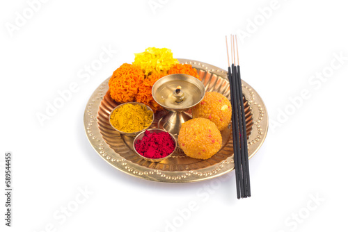 Beautifully Decorated Pooja Thali for festival celebration to worship, haldi or turmeric powder and kumkum, flowers, scented sticks in brass plate, hindu puja thali