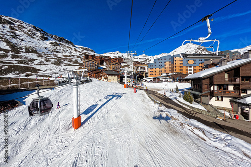 Ski slope in the ski resort of Val Thorens in the French Alps - Snowy track going through a village of wooden chalets in the domain of the Trois Vallées ("Three Valleys"), the largest in the world