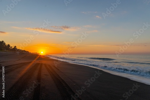 Golden sunrise on a black sand beach in Guatemala