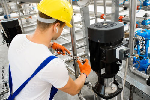 A young factory worker installs water purification equipment.