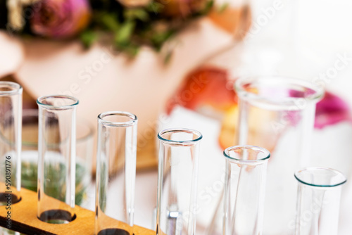 Fresh flowers in chemical test tubes on the table. Preparation of perfumes from natural ingredients, aromatherapy