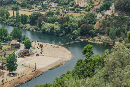 Treetops with leaves on the bank of the Mondego with aerial view of the river beach of Reconquinho, Penacova PORTUGAL