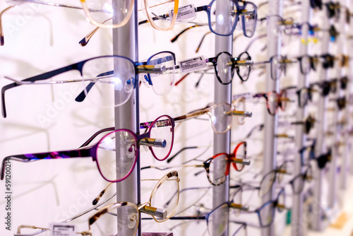 In optician shop. Different glasses for sale in wall rack.