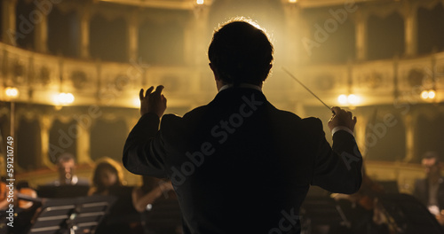 Back View Cinematic shot of Conductor Directing Symphony Orchestra with Performers Playing Violins, Cello and Trumpet on Classic Theatre with Curtain Stage During Music Concert