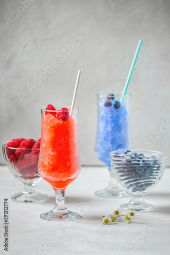Summer Sicilian granite dessert, frozen raspberry, blueberry juice in large glass glasses on a white background. Summer cool, tonic crushed ice cocktail, a kind of sherbet