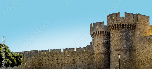 Medieval towers of the gate and defensive walls of the old citadel in Rhodes, Greece. Medieval fortress of crusaders of Maltese knights, panoramic landscape, design element of ancient architecture.