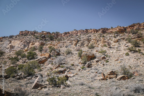 Landscape view of dry desert mesas in western Colorado desert near town of Montrose in spring covered in sage brush and large boulders