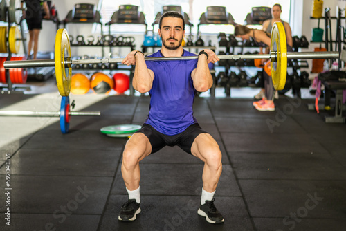 Handsome man in the gym he is concentrated lifting a barbell. Hard training. Crossfit athlete preparing to lift heavy barbell 