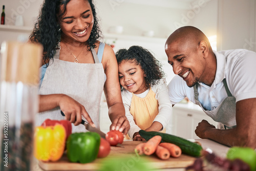 Family, cut and cooking vegetables together or learning chef skill with parents and child in kitchen. Nutrition, healthy food and organic with people teaching and learn to cook at home with bonding