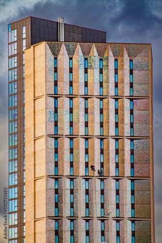 wieżowiec, ludzie na linach myjący okna