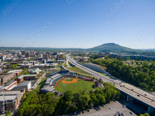 aerial shot of AT&T Field with skyscrapers, office buildings and apartments in the city skyline with lush green trees, grass and cars driving on the highway in Chattanooga Tennessee USA