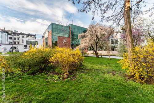 szklany nowoczesny budynek filharmonii opolskiej wiosną wśród zieleni