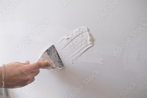 repairing walls with putty and spatula