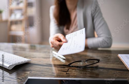 Businessperson's Hand Holding Cheque