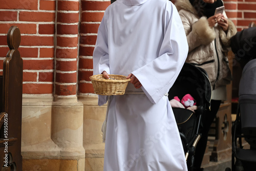 Ministrant zbiera datki do koszyka od wiernych w kościele katolickim. Ofiara. 