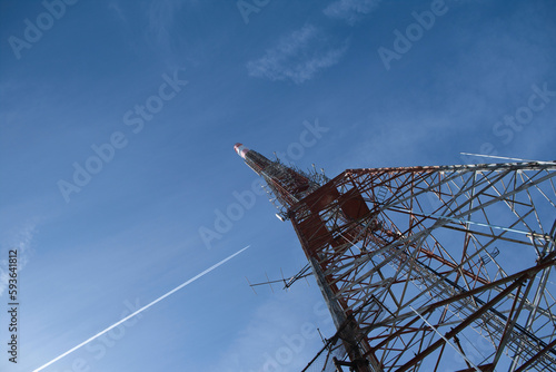 tv transmitter mast and airplane in the sky