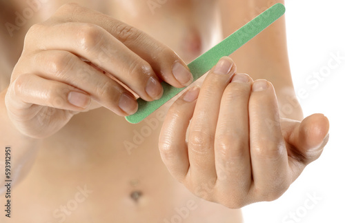 Well-groomed young healthy woman at manicure filing fingernails with nail file