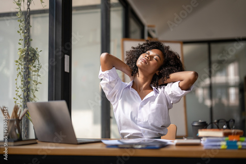 Black woman getting physically active from fatigue sitting at a desk. tired from work, Twisting due to pain, Office syndrome of office workers