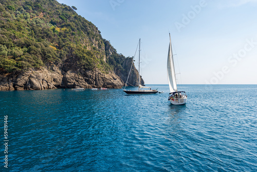 Sailing boats in motion in the blue Mediterranean sea (Ligurian sea) in front of the San Fruttuoso bay between Portofino and Camogli, Genoa province (Genova), Liguria, Italy, Europe.