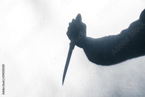 Shadow of a murderer holding a knife