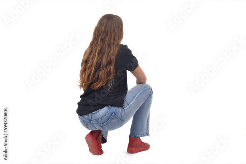 back and side view of a young girl long-haired sitting squatting on white background