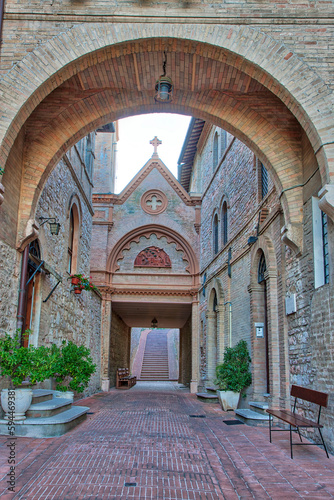 Italy, Umbria, Assisi. Archway and path leading to the Monastero della Santa Croce Catholic Church.