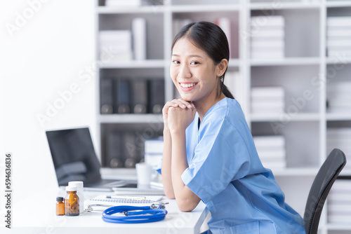 Smiling of doctor recommends taking medicine, supplement, vitamins, Practitioner with bottle of pills. white plastic pill bottle on doctor wooden table. 