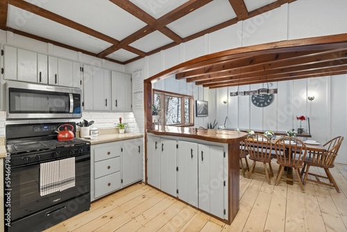 a kitchen with wood floors and ceiling beams next to an oven