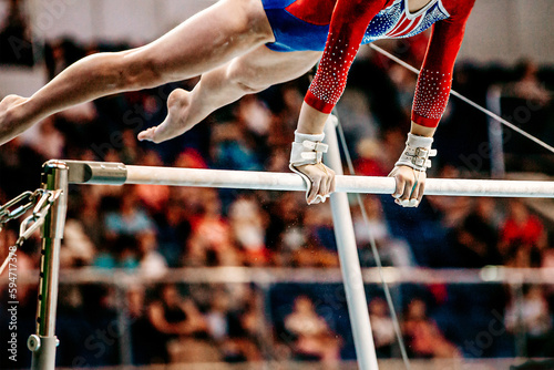close-up body part female gymnast exercise on uneven bars in artistic gymnastics, sports summer games