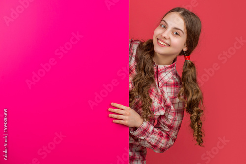 glad girl behind blank pink paper with copy space for advertisement