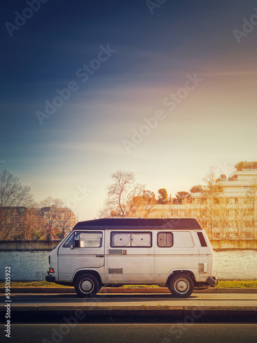 Old van parked on the edge of the street in the sunset sky background, Asnieres sur Seine, Paris suburb, France