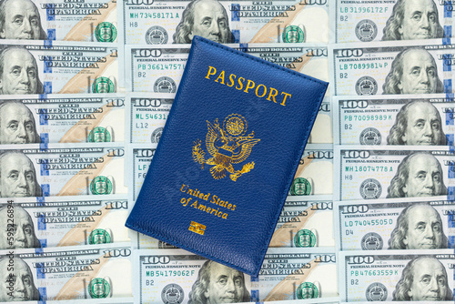 US passports in a pile of US dollar banknotes. US document. an American passport against the background of a large pile of American dollars. The concept of lending or buying fake documents.