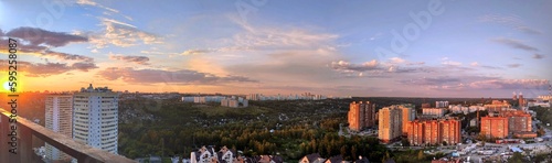 Beautiful sunset over the city filmed from a high floor of a house. Panorama of the city from above.