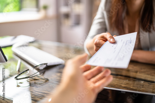 Businesswoman Giving Cheque To Her Colleague