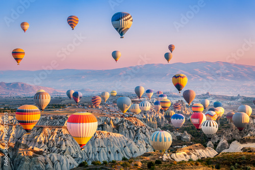 Aerial view of a fleet of hot air balloons, in Cappadocia, Turkey, at sunrise. Cappadocia is a popular tourist destination.